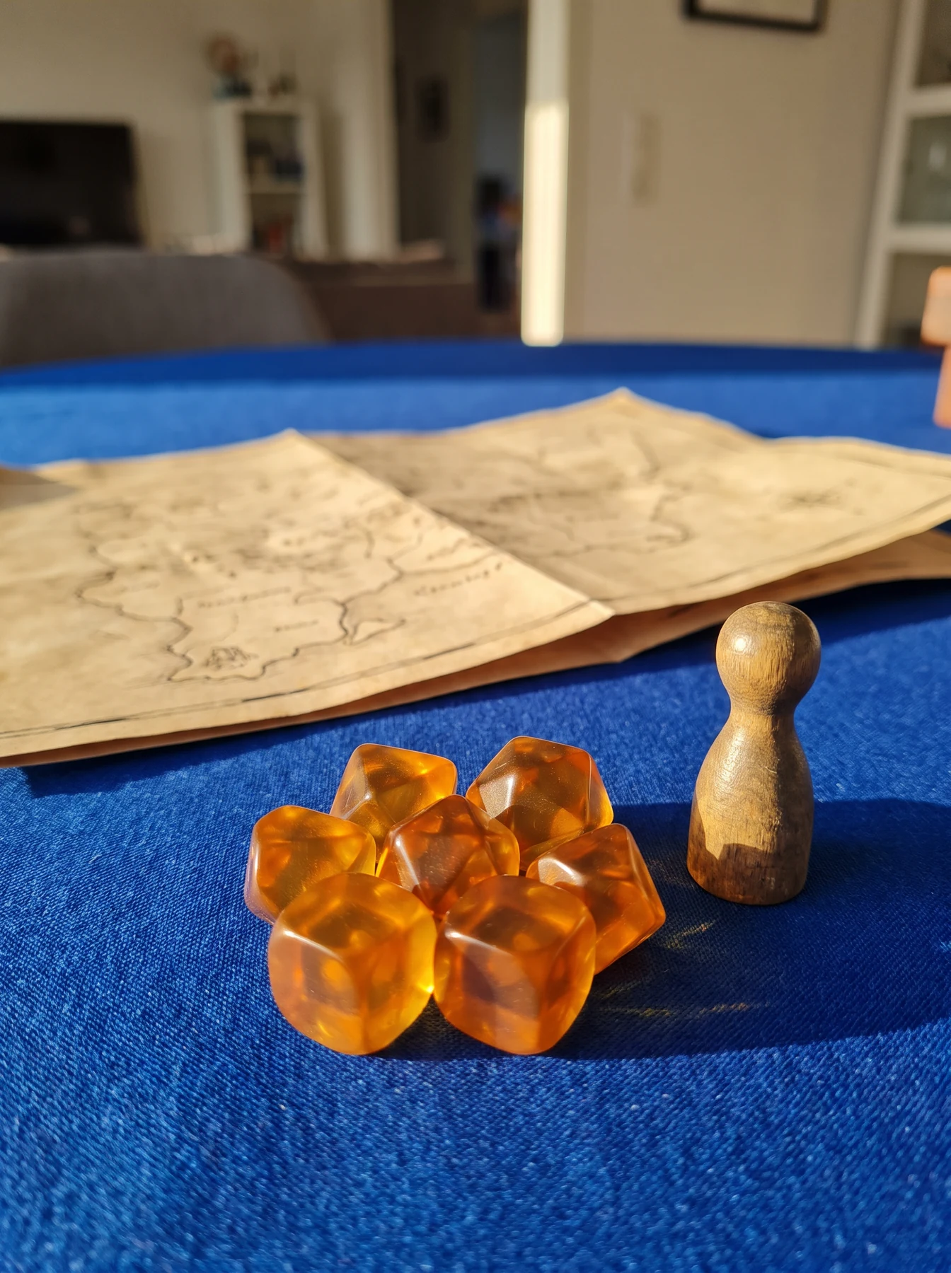 Amber dice and a wooden pawn next to a game map